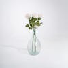 Three white-pink artificial rose stems in glass vase