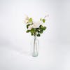 Three artificial wild rose stems in glass vase