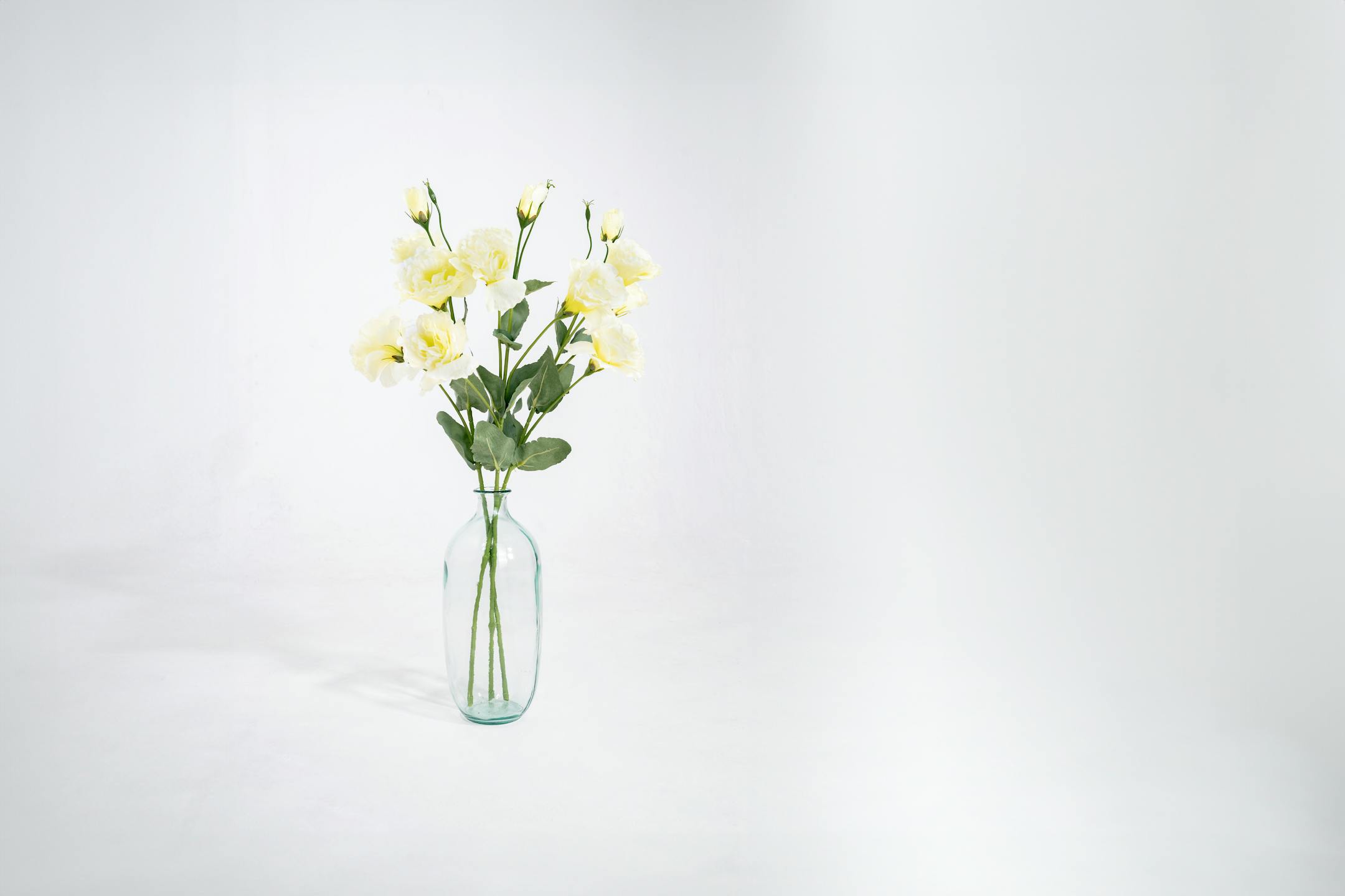 Three cream artificial lisianthus stem in glass vase