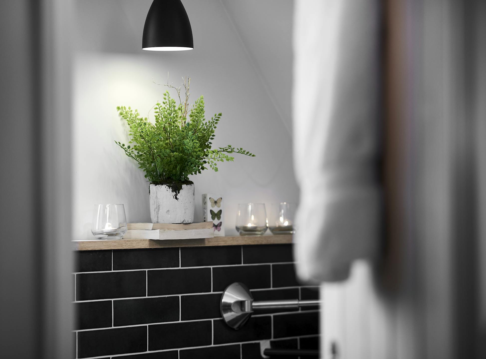 Artificial maidenhair houseplant in tiled bathroom