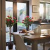 Pair of artificial red rose ball trees in the kitchen dining room either side of double glass doors