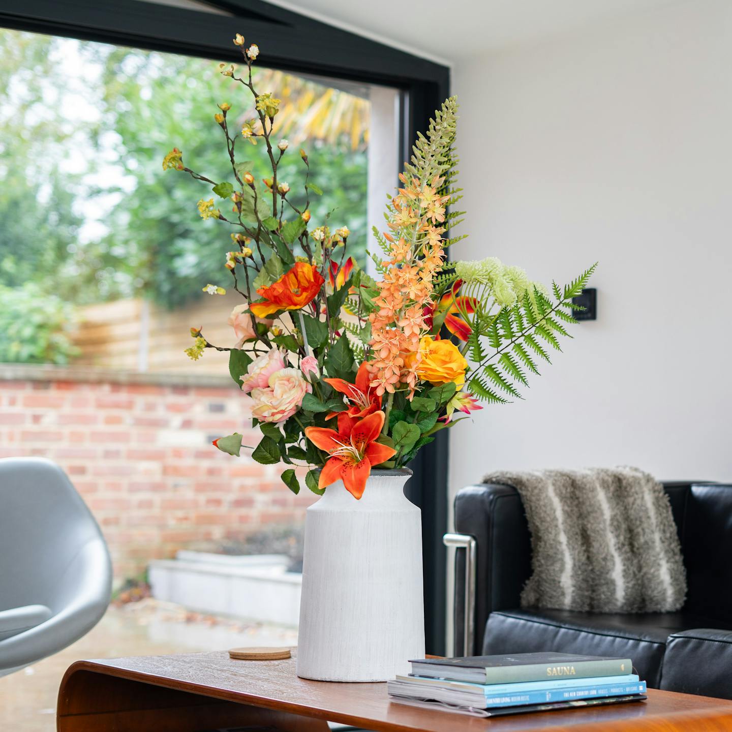 Artificial happy orange arrangement on coffee table