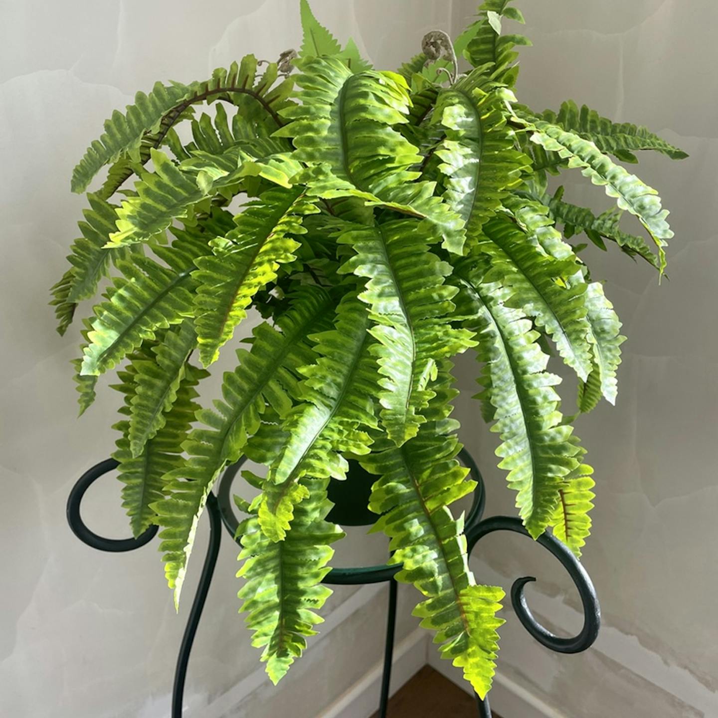 Large artificial Boston fern on plant stand