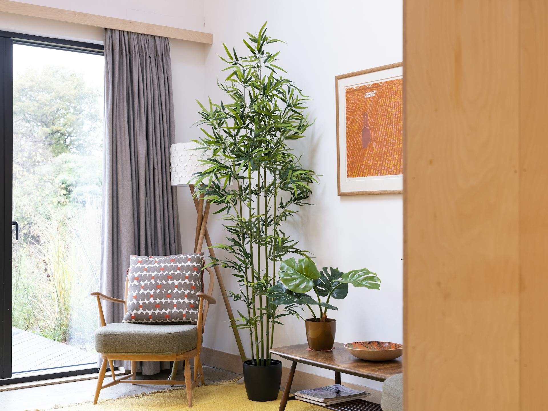 Artificial green stem bamboo and monstera plant in living room