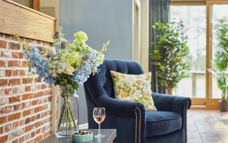 Faux highland spring bouquet with blue armchair