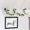 Variegated artificial ivy garland string wrapped around white beam