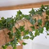 Artificial green ivy garland wrapped around oak beam