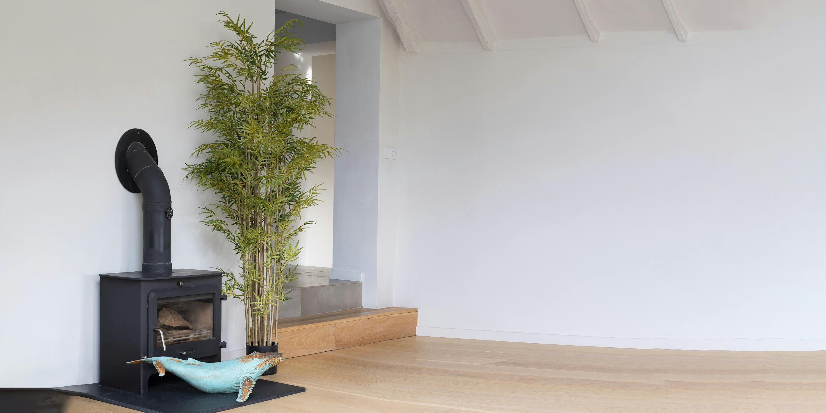 Large artificial Japanese style bamboo indoor plant by log burner