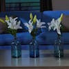 Artificial oriental lily stem in glass vase in living room
