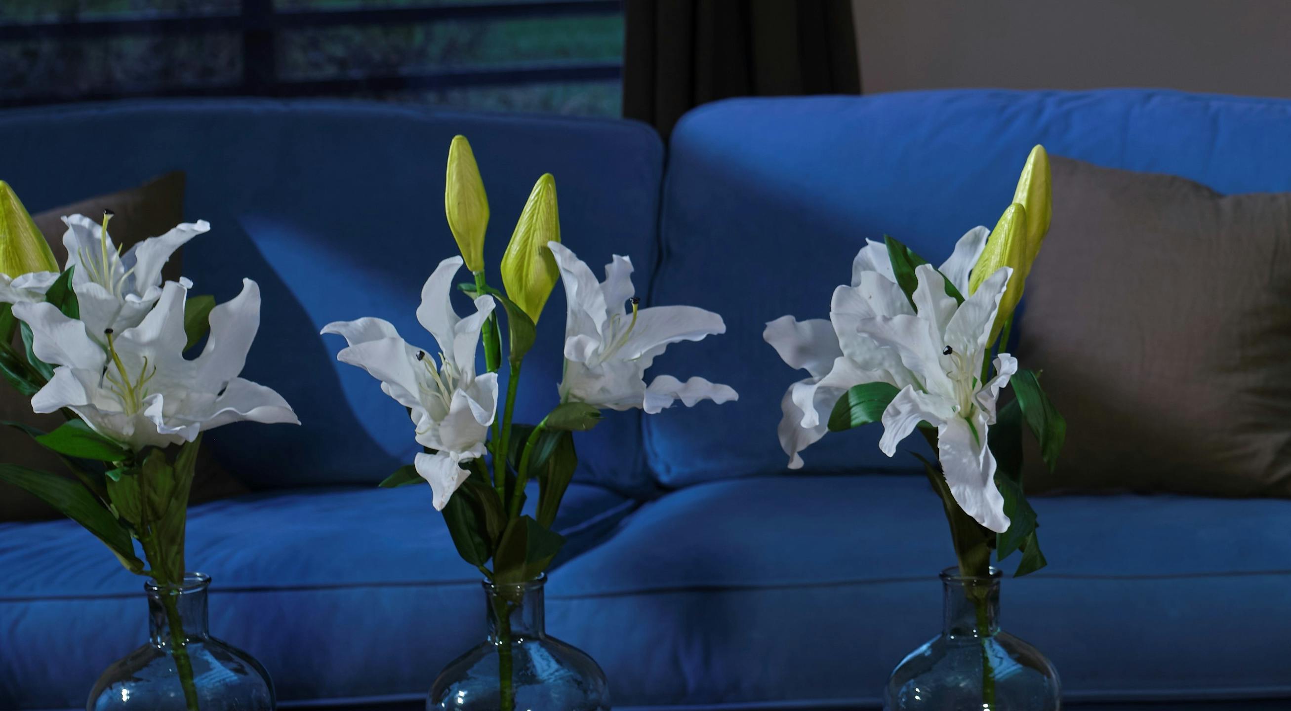 Artificial oriental lily stem in glass vase in living room