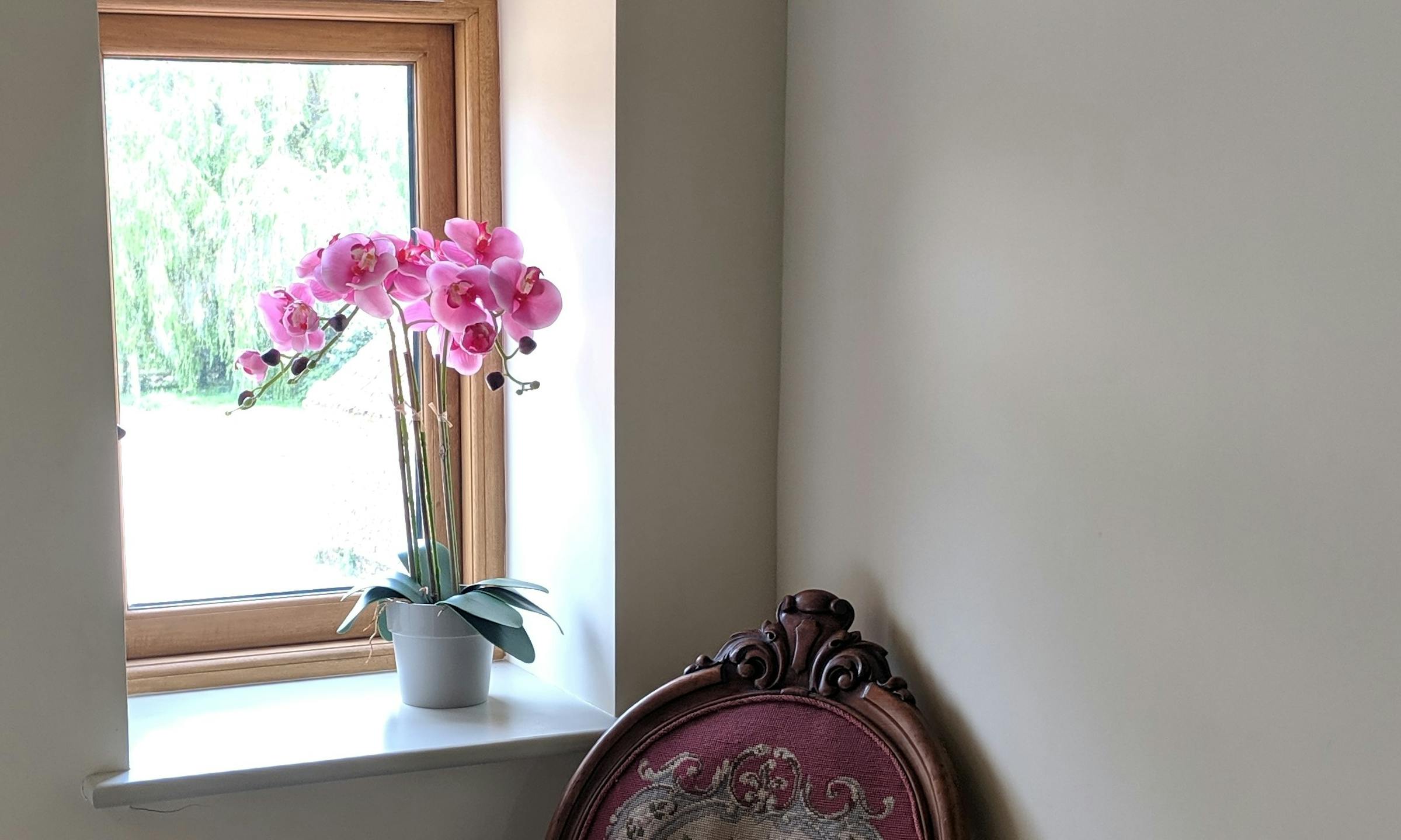 Pink artificial phalaenopsis orchid on window sill