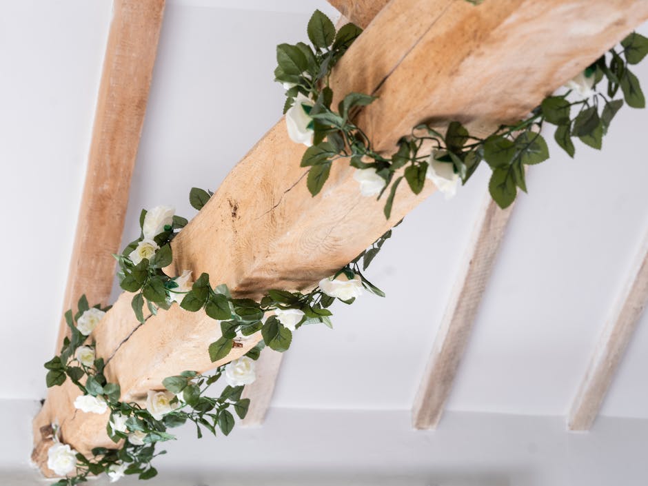 Artificial white rose garland wrapped around wooden beam
