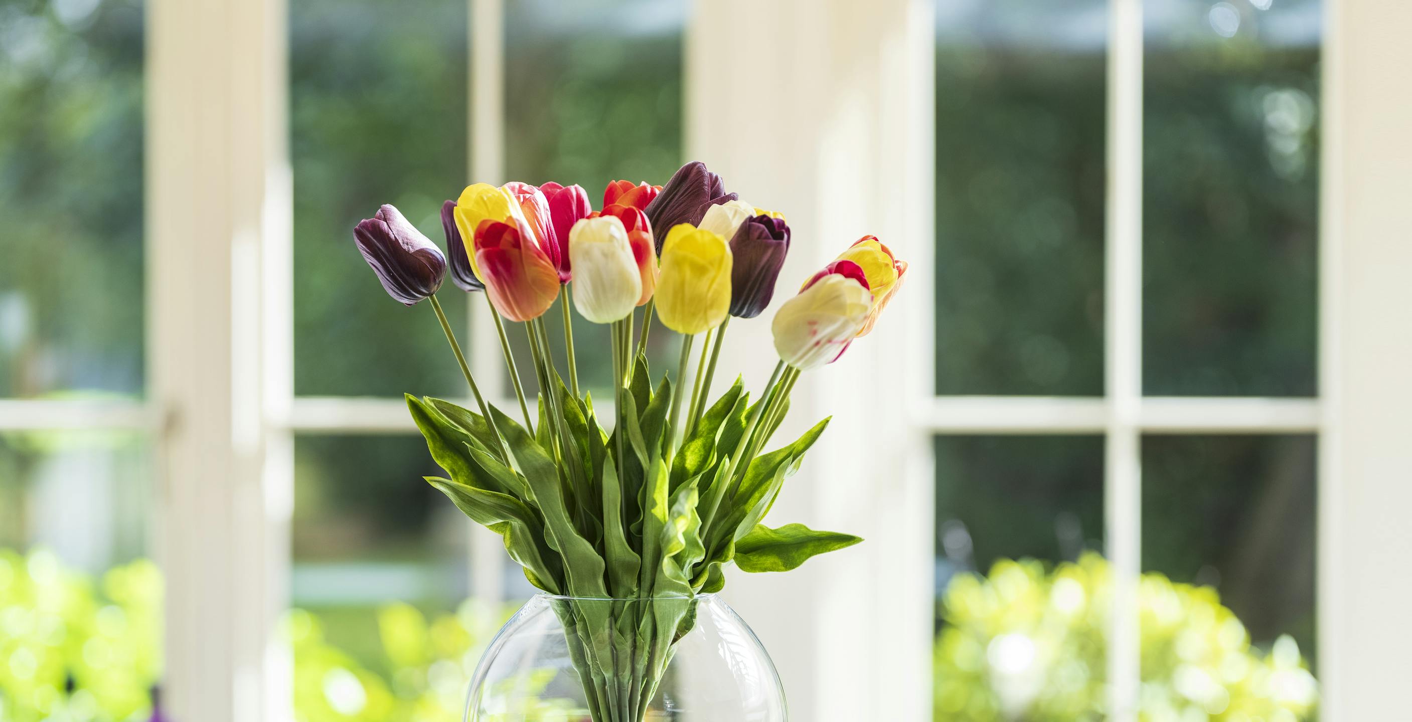 Bunch of artificial tulips on kitchen counter