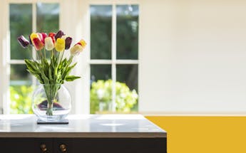 Bunch of artificial tulips on kitchen counter