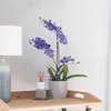 Purple artificial vanda orchid on side table