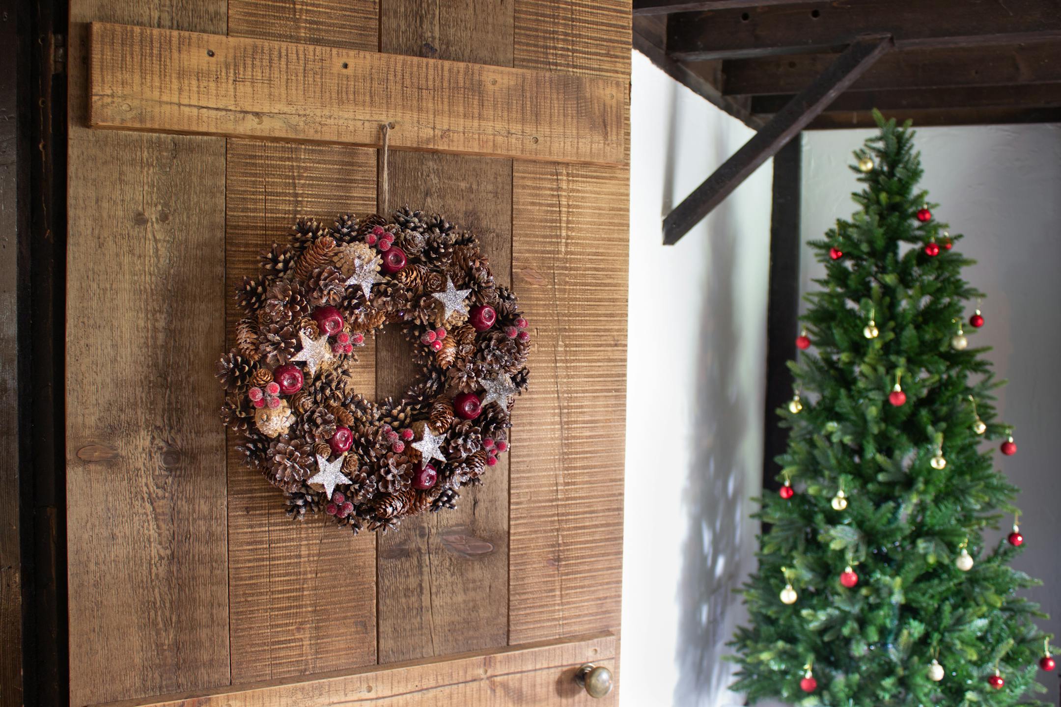 Artificial winter spice wreath on wooden door
