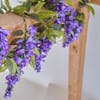 Purple artificial wisteria garland by Blooming Artificial wrapped around oak beam