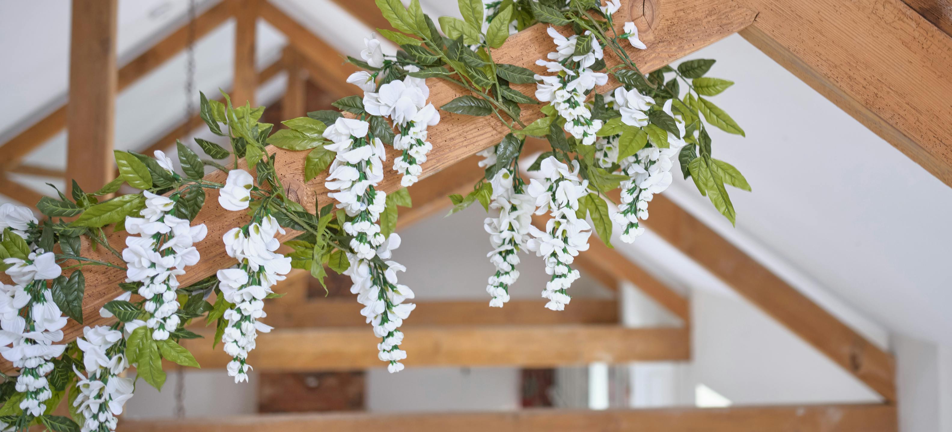 White artificial wisteria garland on oak beam