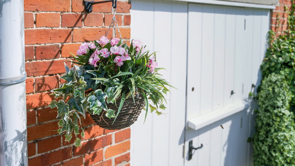 Artificial busy lizzie hanging basket outside red brick house